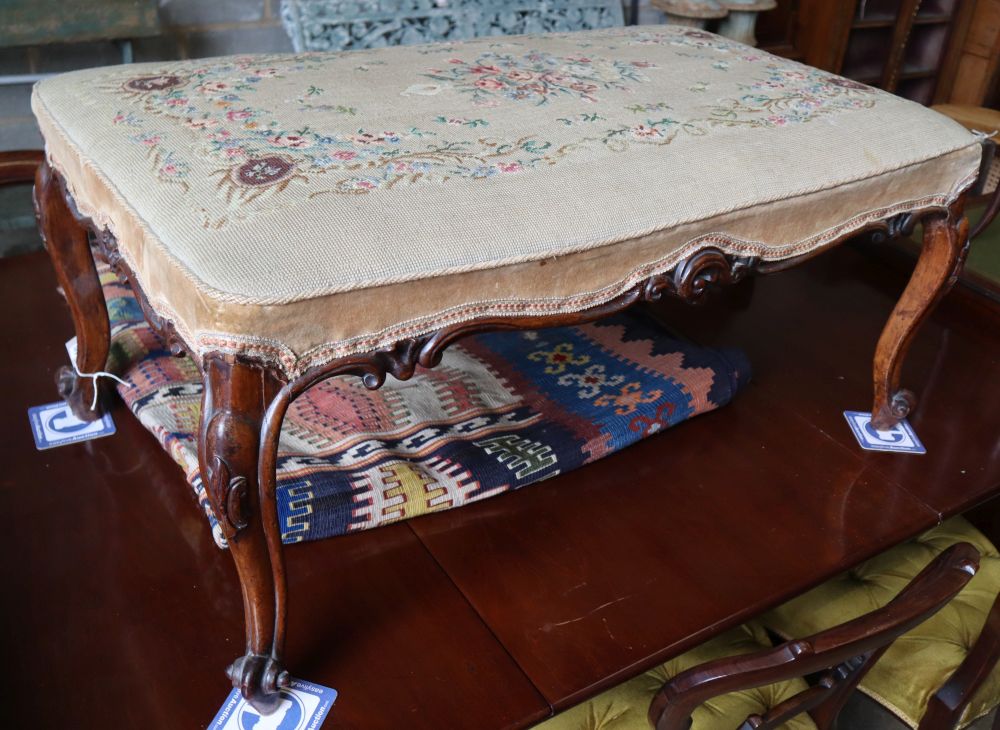 A Victorian carved walnut dressing stool, with tapestry seat, width 96cm depth 60cm, height 43cm